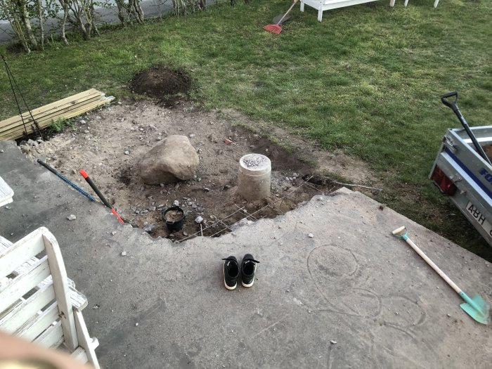 Renoveringsarbete utomhus med verktyg, byggmaterial och en delvis borttagen betongplatta.