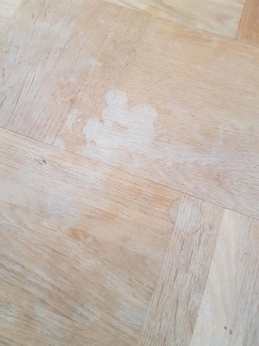 Parkettgolv med vita vattenfläckar och smutsiga märken, behöver råd om behandling.