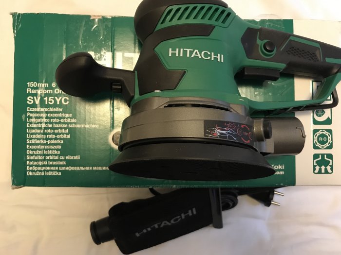 Excenterslipmaskin från Hitachi med reglage för omloppsdiameter och hastighetsjustering på förpackning.