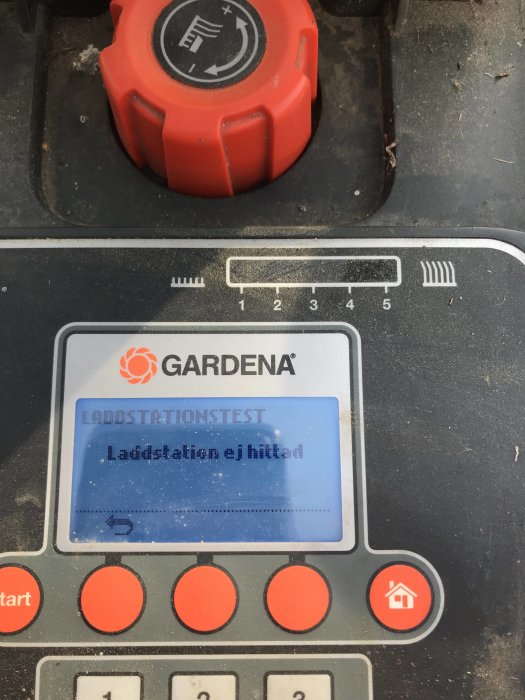 Display på en Gardena R40 robotgräsklippare som visar felmeddelande "Laddstation ej hittad".