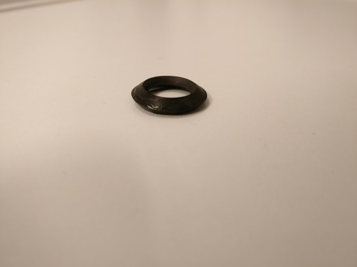En gammal svart packning ligger på en vit yta.