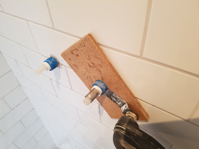 DIY-projekt med hemmagjord skyddsrörsplatta av ihoplimmade masonitbitar för väggrör.