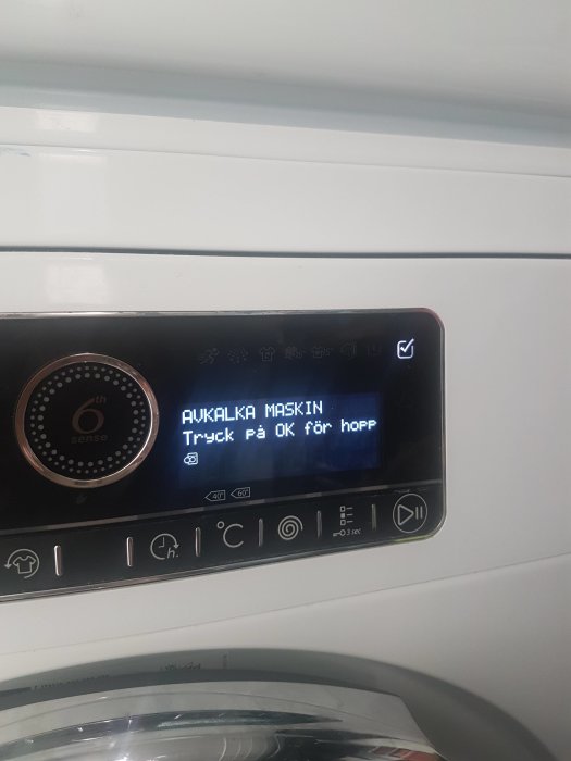 Display på Whirlpool tvättmaskin visar meddelandet "AVKALKA MASKIN Tryck på OK för håpp".