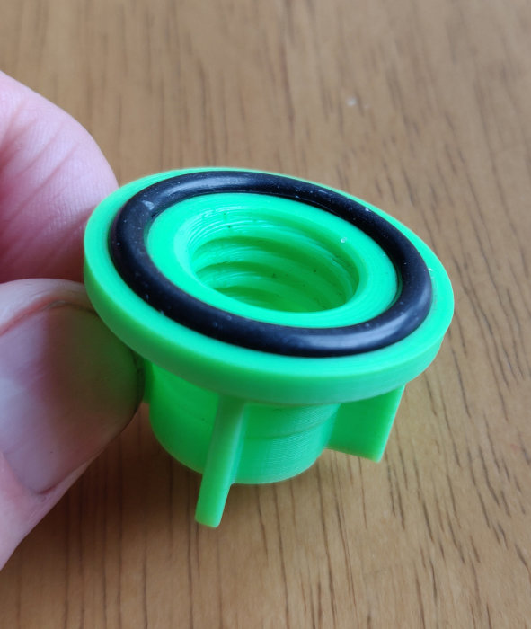 Grön 3D-printad kork med o-ring för att försegla silikon- och limtuber mot uttorkning.