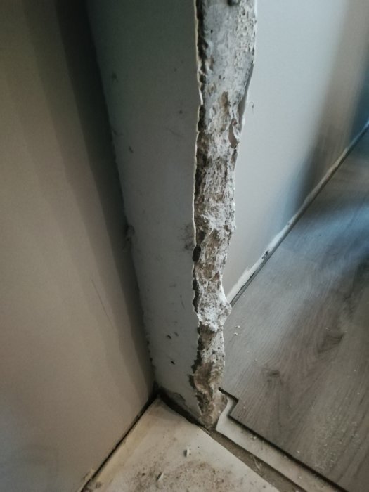 Skadad vägg och armering där gammal dörrkarm tagits bort under en lägenhetsrenovering.