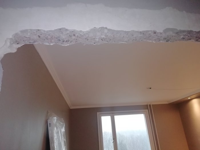 Renoverad dörröppning med exponerad armering och gipsblock efter borttagen karm.