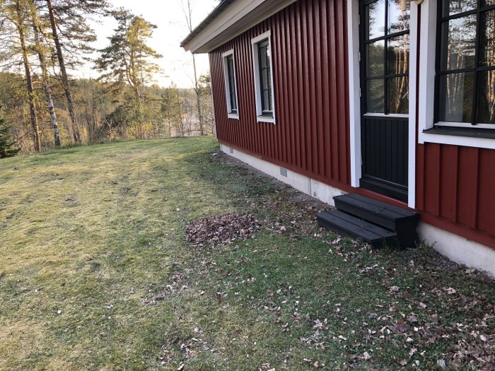 Husets sida där gräsmarken ska omvandlas till en altan med uterum, ingen byggstruktur synlig än.