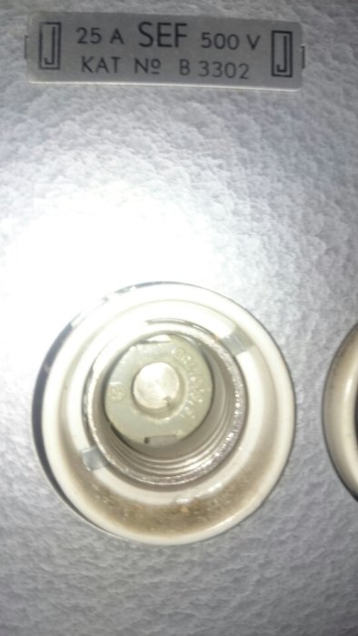 Närbild på ett gammalt diazed säkringsuttag med etikett "25 A SEF 500 v KAT Nº B 3302".