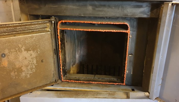 Öppen kakelugn med synlig ny högtemperatur silikonpackning runt kanten.