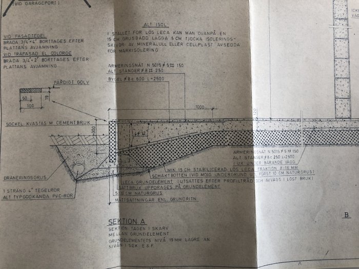 Ritning av en husgrund från 70-talet visar sektioner utan isolering under betongplattan och Leca som underlag.