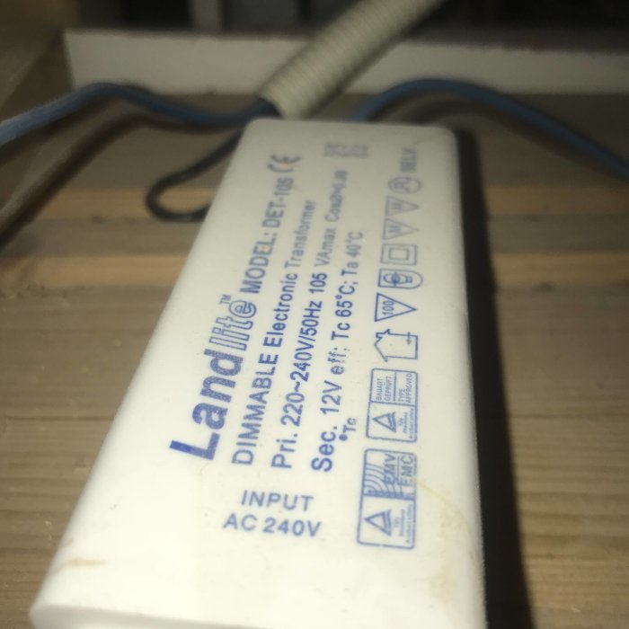 En transformator märkt "Landlite DIMMABLE ELECTRONIC TRANSFORMER" monterad på träyta.