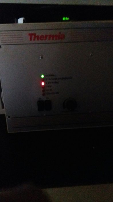 Thermia elpanna med en röd lampa för "4 kW TRIAC" som lyser och grönt NORMAL-ljus.