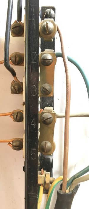 Elektrisk anslutning i en gammal spis med märkning av positionerna 1 till 5, kopplade ledare och bleck.