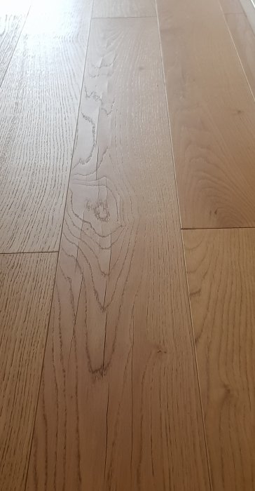 Enstavsparkettgolv i ek med tydliga sprickor som har uppstått i träet efter 18 månader.