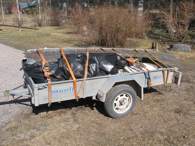 En släpvagn lastad med säckar av insamlad småplast redo för sophantering.