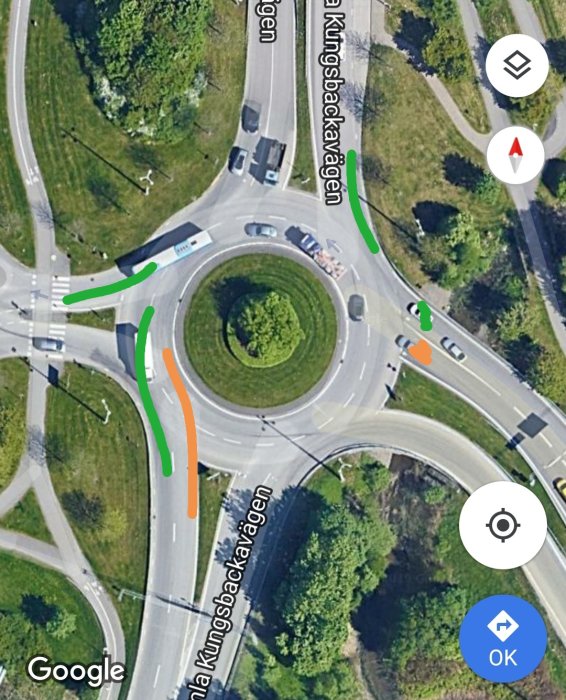 Satellitbild på rondell med markerade vägar för orange och grön bil enligt beskrivning.