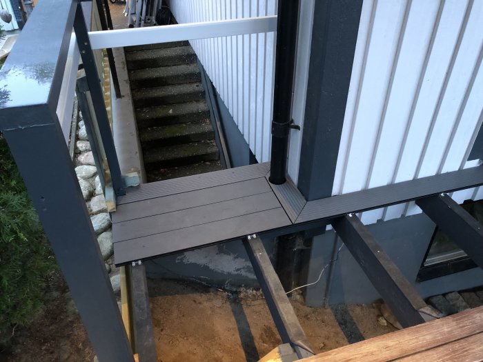 Installation av komposit-trall och kantsten vid husets entrétrappa.
