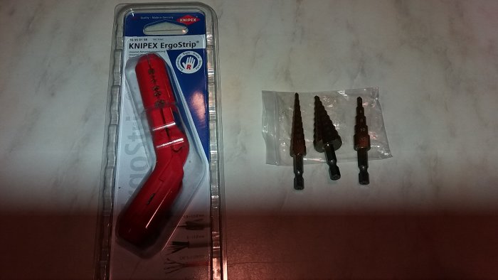 Verktygspresent med en Knipex ErgoStrip verktyg och steppborrar på bord.