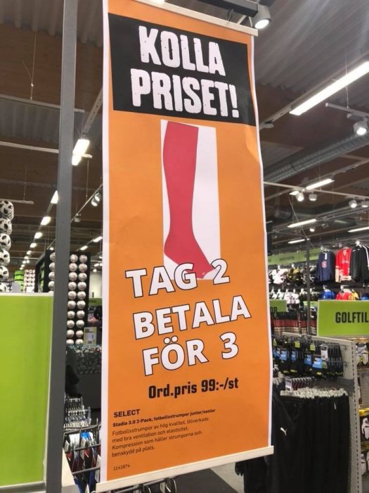 Skylt med erbjudandet 'Tag 2 betala för 3' och ordinarie pris på butiksgolv med sportartiklar i bakgrunden.