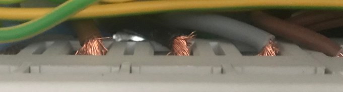 Elektriskt fel där oskyddade kopparkablar syns i en ledningskanal.