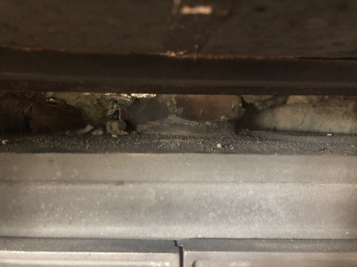 En närbild på en horisontell del av en konstruktion med möjlig spackling och damm.