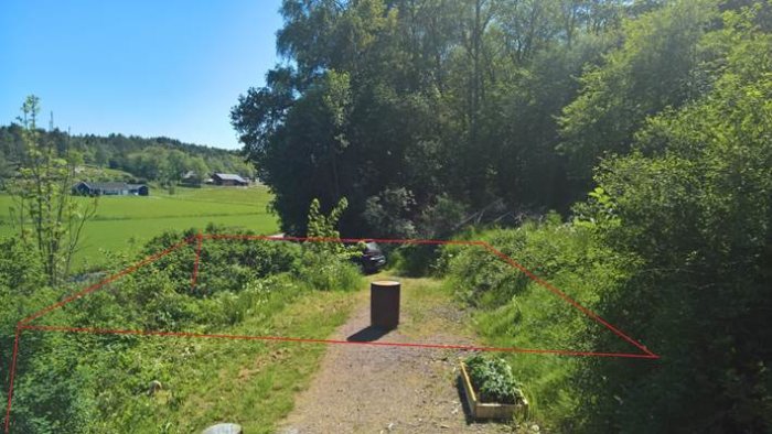 Vy över en framtida trädgård, markerad yta för höjning med gabioner ut mot vägen.