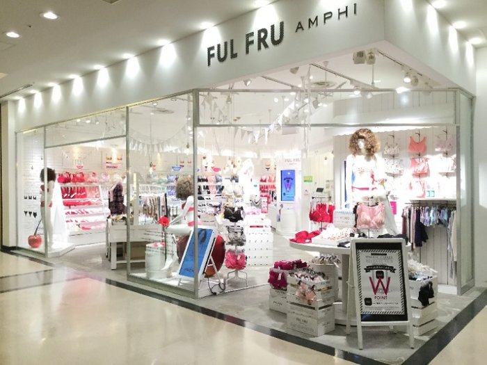 Entré till en ljus damklädesbutik i Japan med rosa och vita kläder och accessoarer i skyltfönster.