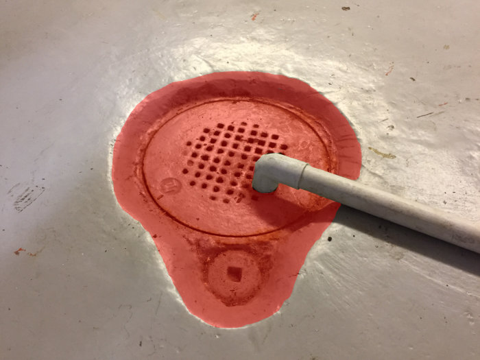 Rosa formad konstruktion med självnivilerande massa och ett rör, förberedd för gjutning och borrning.