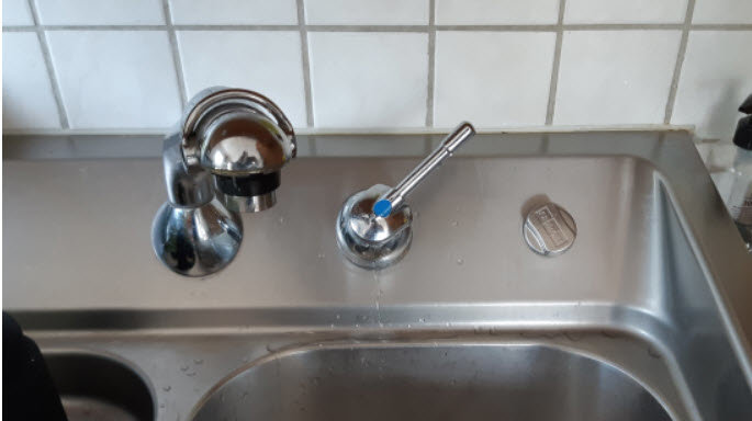 Gammal FRANKE köksblandare och pip monterade på 45° lutning över diskhon.