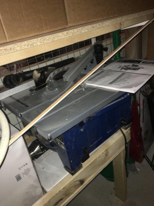 Bordssåg för laminatgolv med sågat virke placerad i ett förråd, använd inför renovering.