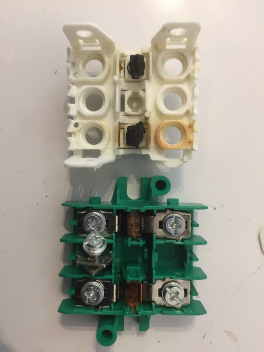Delvis sönderbränd och öppnad elektrisk arbetsbrytare med synliga skador och tecken på överhettning.