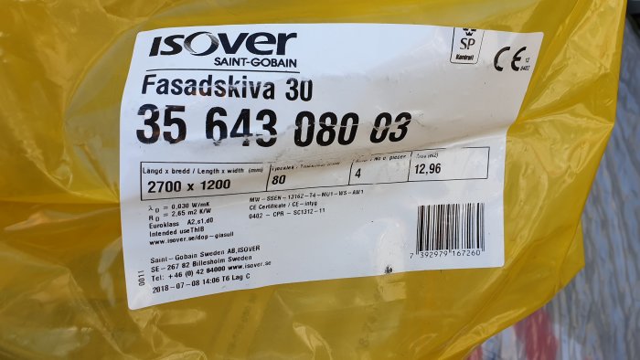 Etikett på gul Isover Fasadskiva 30 visar produktinformation och dimensioner för byggisolering.