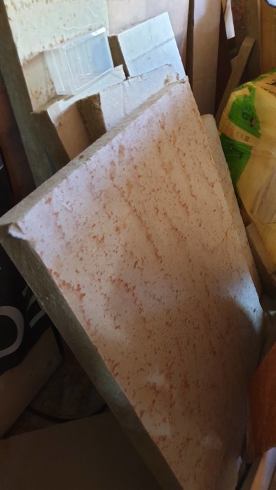 Förvaringsutrymme med olika typer av isoleringsskivor och förpackningar synliga.