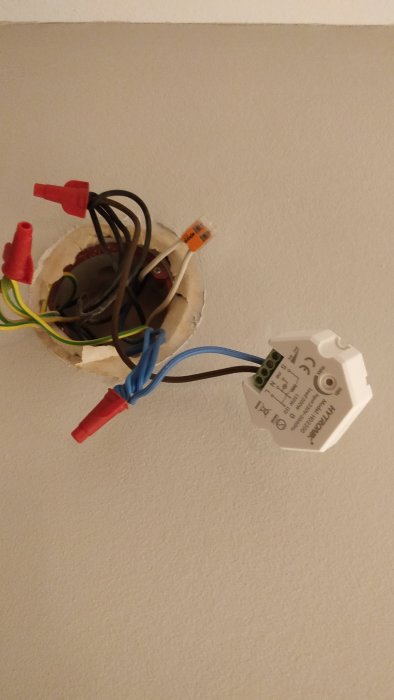 Elektrisk installation i väggdosan med synlig hytronik dosdimmer och kopplade kablar.