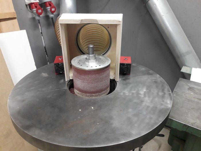 Uppgraderad cylinderputs med flyttbar utsugshuv och modifierade magnetfästen på ett arbetsbord i verkstaden.