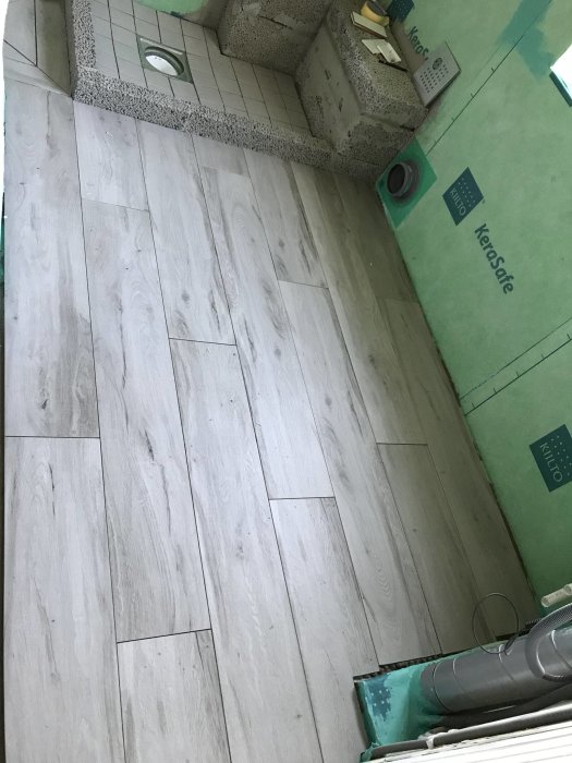 Nylagt ljust laminatgolv i ett oavslutat badrum utan fogsprång.