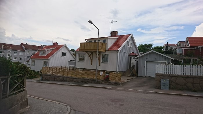 Nybyggd balkong på 4,8m x 2m med hängande konstruktion konsolerad mot husets fasad, belägen nära trottoaren.