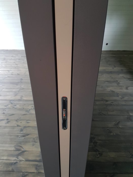 Ojämn fog mellan en MDF-panel och gipstak med synliga springor och en vattenpass i mitten.