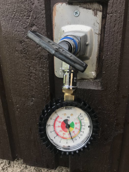 Manometer monterad på vägg som visar vattentrycket, hopsatt med delar köpta från Jula.