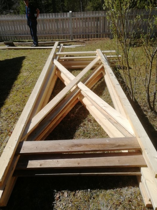 Träställning under konstruktion på gräsmatta inför tak- och fasadrenovering.