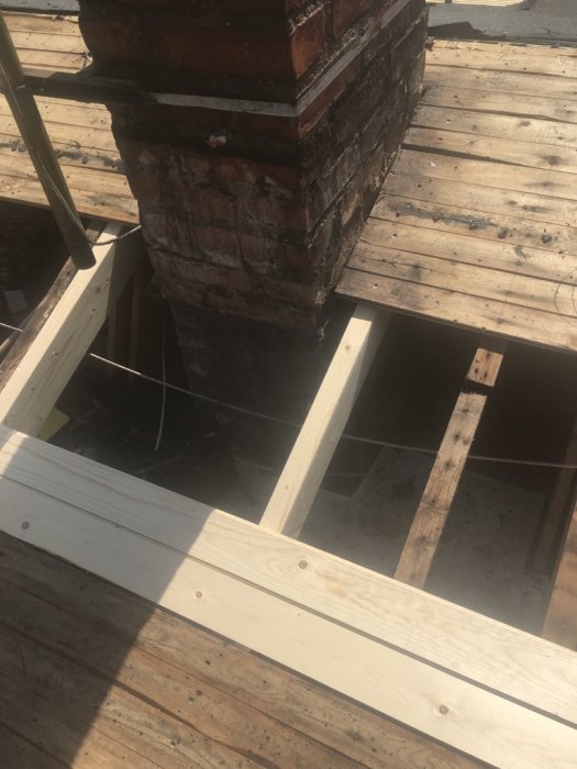 Byte av råspont och förberedelse för ytpapp nära en skorsten på ett hustak från 1963.