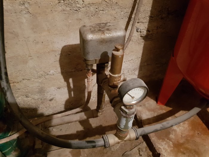 Gammal vattenpump med mätare i källare, använd för trädgårdsbevattning sedan 70-talet.
