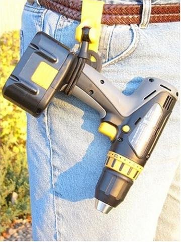 En sladdlös borrskruvdragare hängande i ett gult verktygsbälte fäst vid någons jeans.