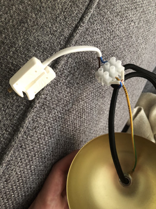 En ojordad vit lamppropp kopplad till lampa via färgkodad kabel med blå och brun ledare och skyddsjord.