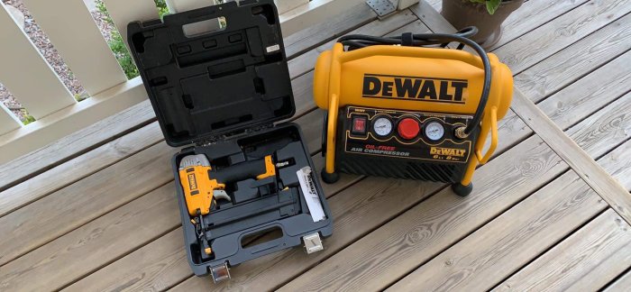 Dewalt dyckertpistol och kompressor set på en träterrass, i bra skick med lite tecken av användning.