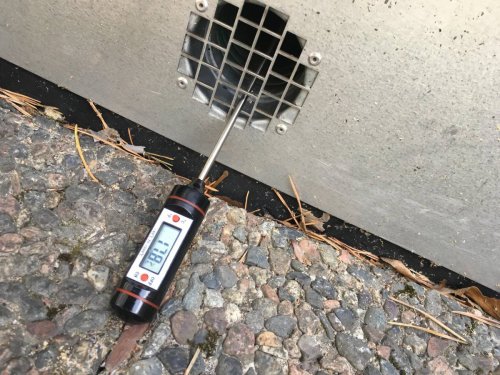 Termometer som visar hög luftfuktighet nära en avfuktarens våtluftstos.