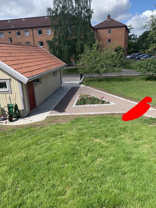 Översiktsbild på en trädgård med grusgång, bredare stenband markerat med röd linje, garage, gräsmatta och blomrabatt.