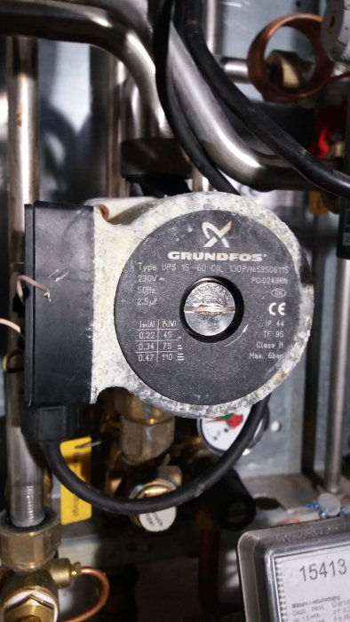 Grundfos cirkulationspump med typbeteckning och specifikationer synlig i en teknisk installation.