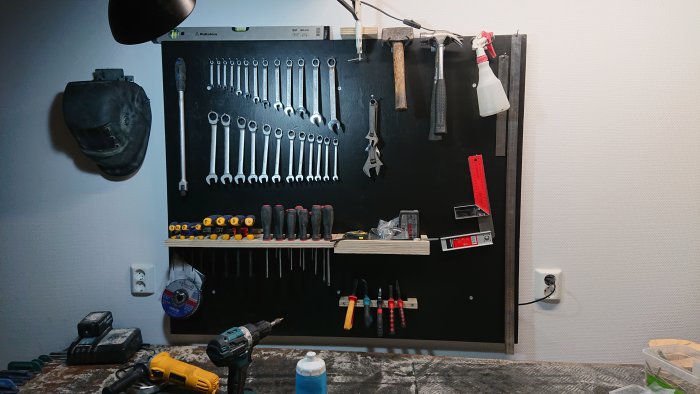 Hemmagjord verktygsvägg av plyfa med upphängda nycklar, skruvmejslar och andra verktyg.