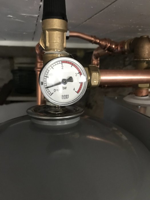Manometer visar vattentryck på ungefär 1.5 bar i ett värmesystem.